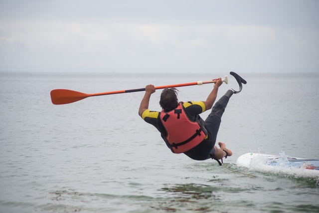 Man falling off paddleboard