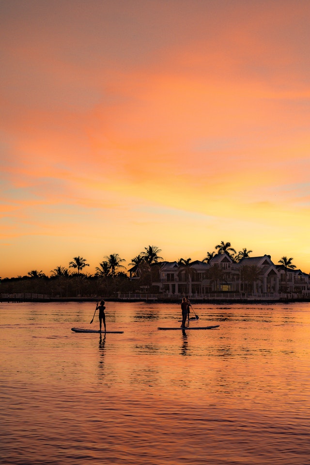 Couple sunset paddleboarding on river