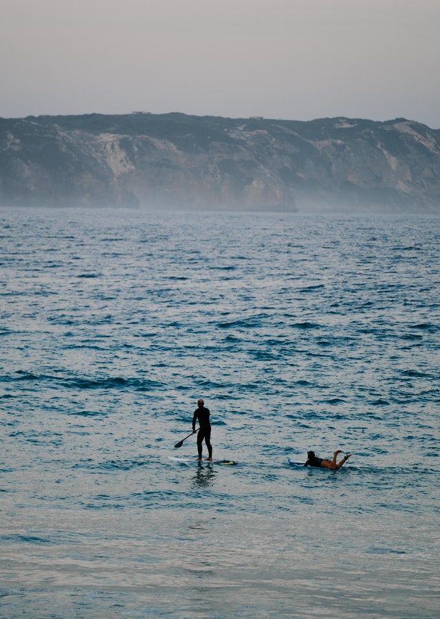 Couple paddleboarding on ocean